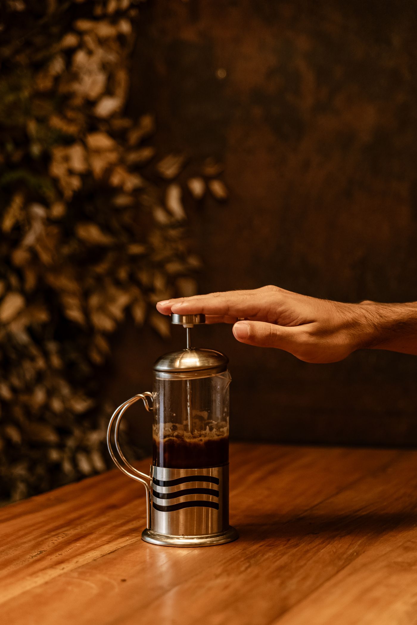 Hand pressing down a French press plunger