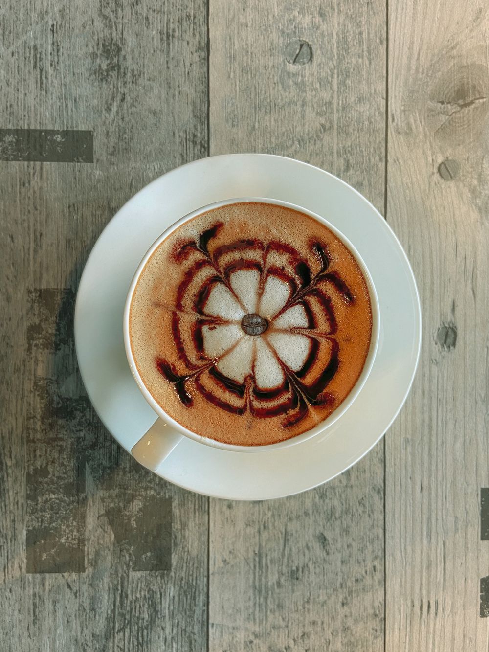 Flower latte art viewed from above on a wooden table
