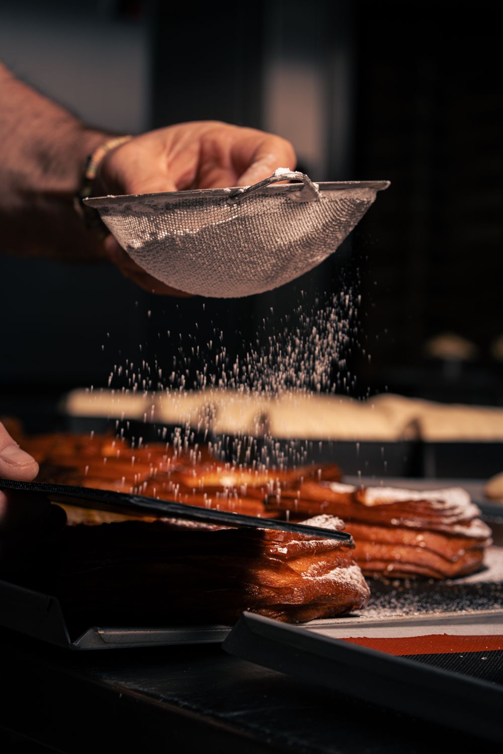 Pastry being dusted with sugar