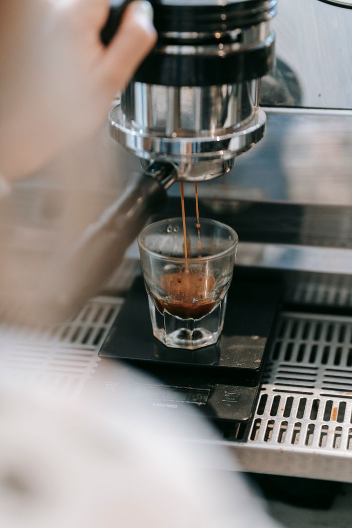 A shot of espresso extracting into a glass