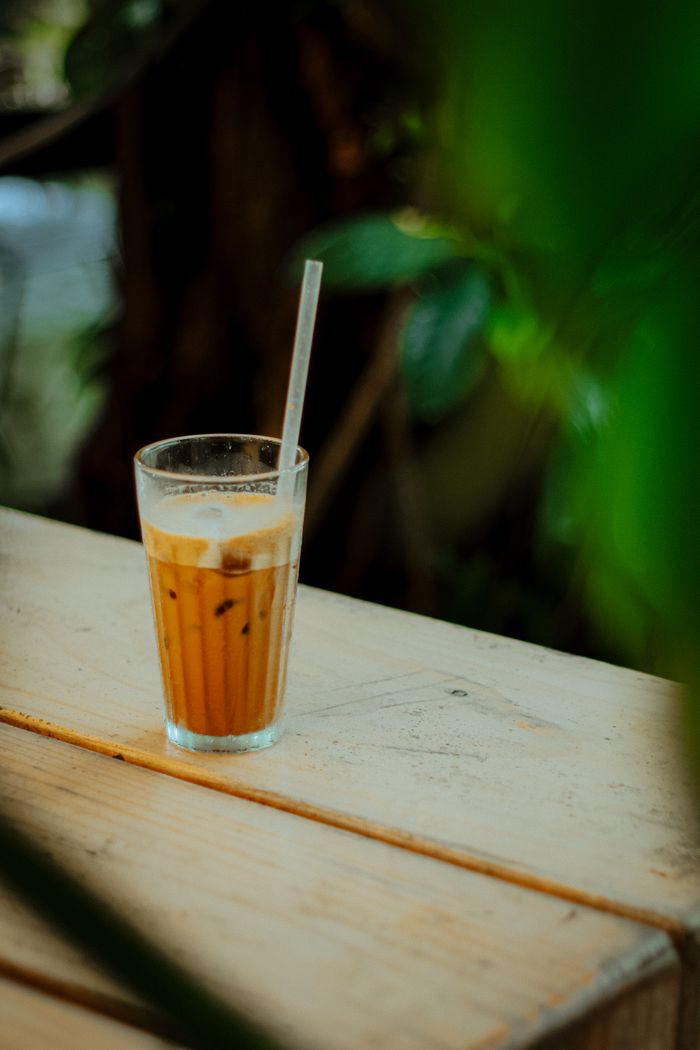Iced latte with milk being poured over ice